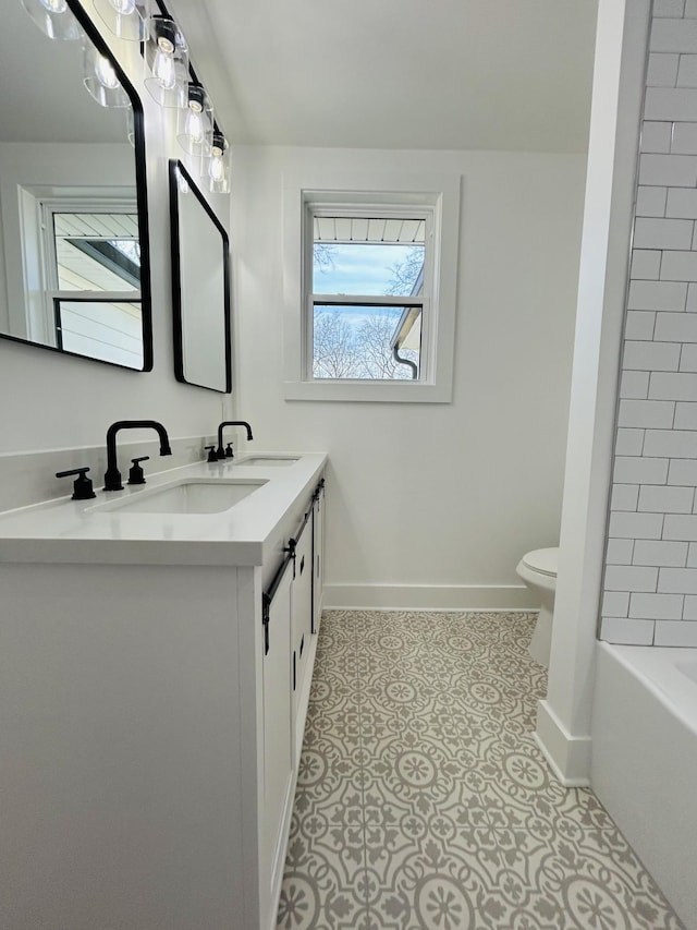 full bathroom featuring vanity, tiled shower / bath combo, tile patterned floors, and toilet