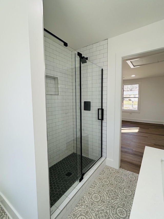 bathroom with an enclosed shower and tile patterned floors