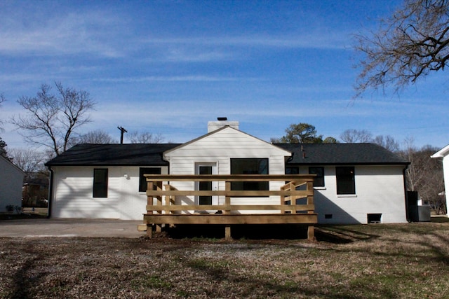 rear view of house featuring a wooden deck and a yard