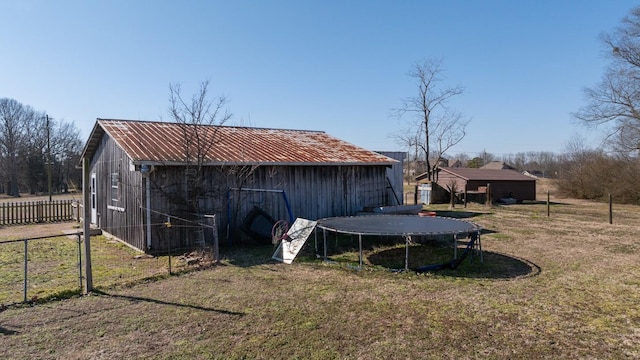 view of outdoor structure with a yard and a trampoline