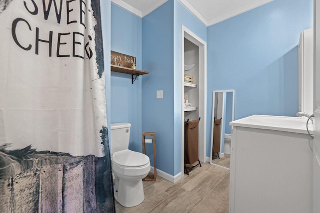 bathroom featuring vanity, ornamental molding, and toilet