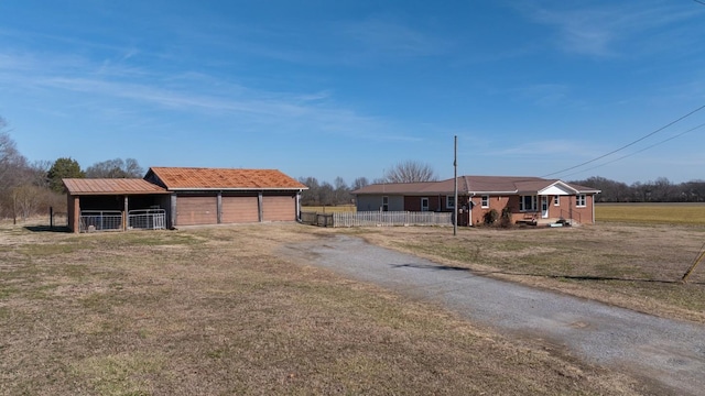 view of front of home featuring a garage, an outdoor structure, and a front lawn