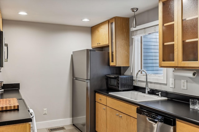 kitchen with appliances with stainless steel finishes, sink, and pendant lighting