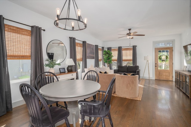 dining space featuring dark hardwood / wood-style flooring and ceiling fan with notable chandelier