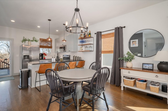 dining room featuring a chandelier, dark hardwood / wood-style floors, and a healthy amount of sunlight