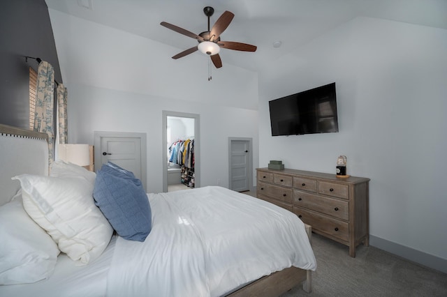 bedroom with vaulted ceiling, a spacious closet, light colored carpet, and ceiling fan