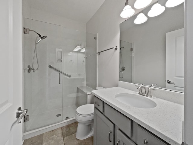 bathroom with vanity, a shower with door, and toilet