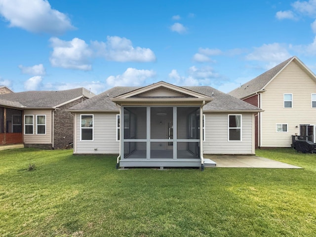 rear view of property with a sunroom, a yard, and a patio area