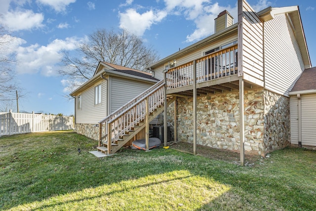 rear view of property with a wooden deck and a lawn