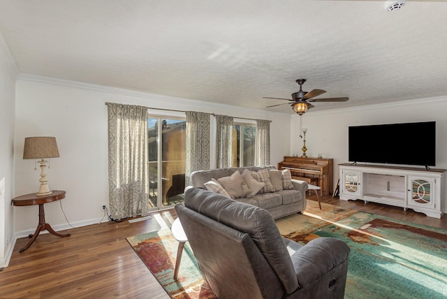 living room featuring crown molding, dark hardwood / wood-style floors, a textured ceiling, and ceiling fan