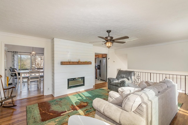 living room featuring crown molding, hardwood / wood-style floors, ceiling fan, and a textured ceiling