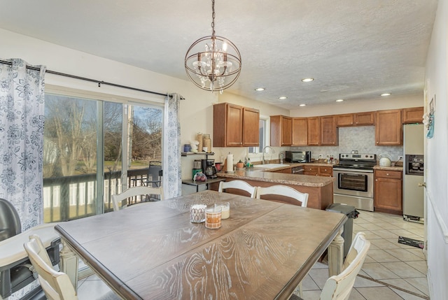 dining area featuring light tile patterned floors, a notable chandelier, sink, and a textured ceiling