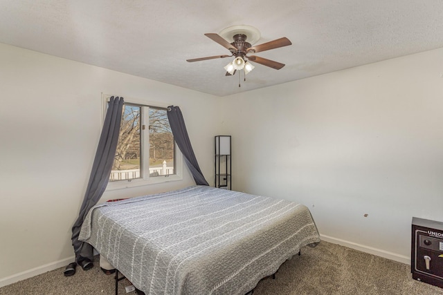 carpeted bedroom featuring ceiling fan and a textured ceiling