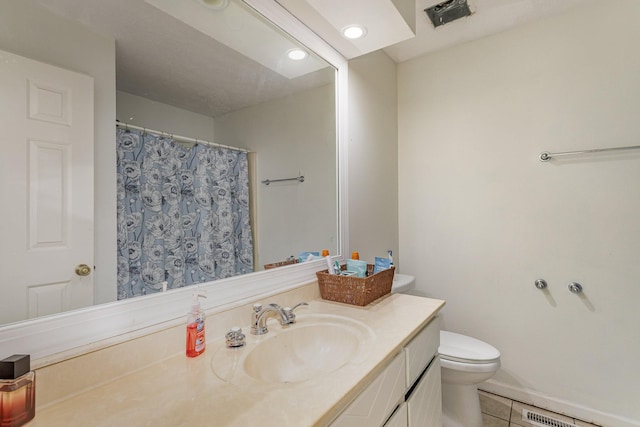 bathroom with tile patterned flooring, vanity, and toilet