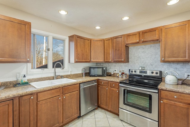 kitchen with sink, backsplash, stainless steel appliances, and light tile patterned floors