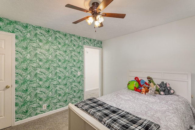 carpeted bedroom with ceiling fan and a textured ceiling