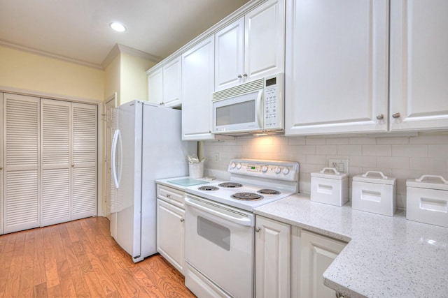 kitchen with white cabinetry, white appliances, light stone countertops, and decorative backsplash