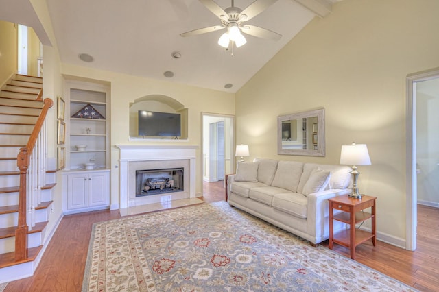 living room with hardwood / wood-style floors, beamed ceiling, high vaulted ceiling, and ceiling fan