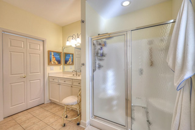 bathroom featuring tile patterned floors, a shower with door, and vanity