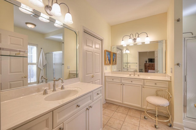 bathroom featuring a shower with door, vanity, and tile patterned floors