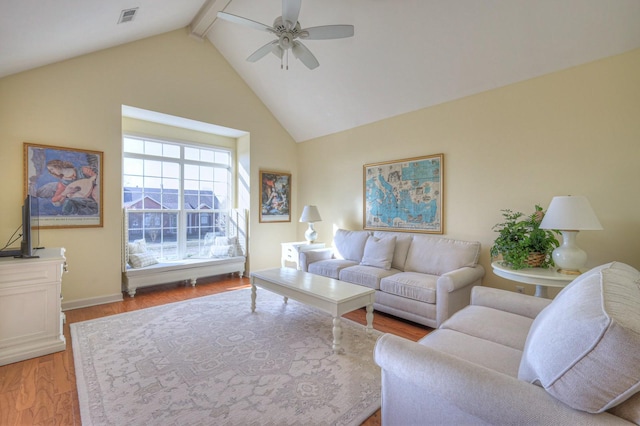 living room with high vaulted ceiling, beam ceiling, light hardwood / wood-style floors, and ceiling fan