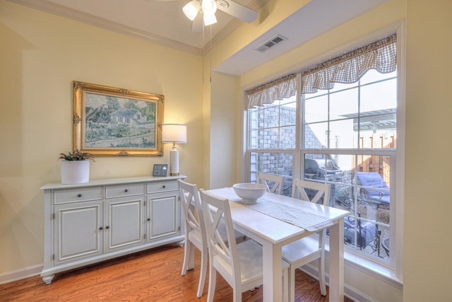 dining room with ceiling fan, ornamental molding, and light hardwood / wood-style floors