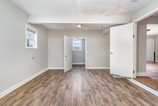 unfurnished room featuring dark wood-type flooring and plenty of natural light