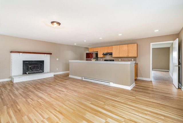 kitchen with a baseboard radiator, stainless steel fridge, light hardwood / wood-style floors, and light brown cabinets