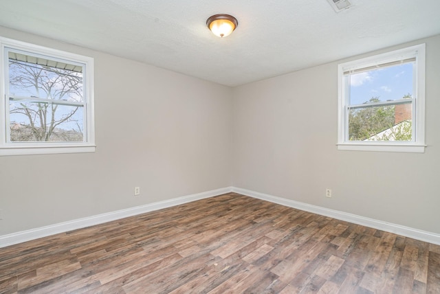 empty room featuring dark hardwood / wood-style floors and a textured ceiling