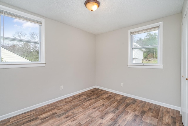 spare room featuring wood-type flooring and a textured ceiling