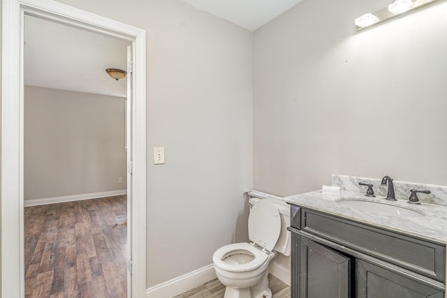 bathroom featuring vanity, toilet, and hardwood / wood-style floors