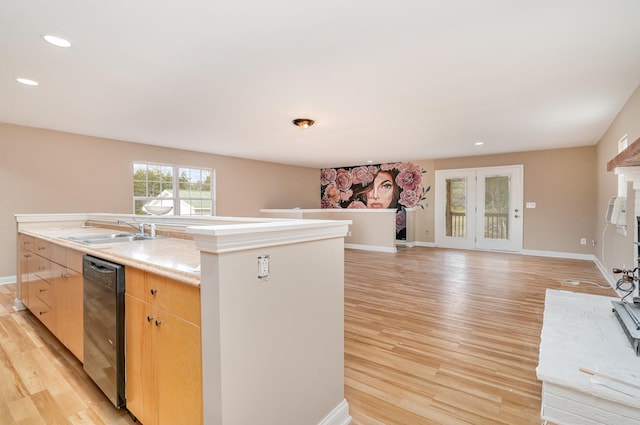 kitchen featuring black dishwasher, sink, a kitchen island with sink, light hardwood / wood-style floors, and light brown cabinets