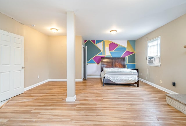 bedroom with cooling unit and light hardwood / wood-style floors