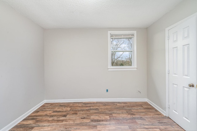 spare room with hardwood / wood-style floors and a textured ceiling