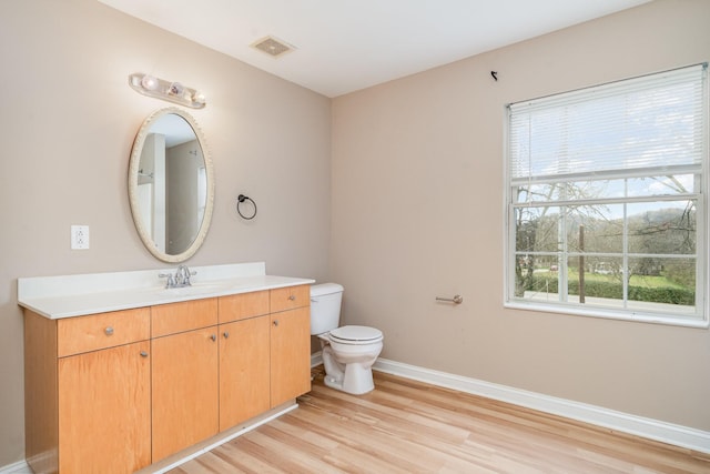 bathroom featuring vanity, toilet, and hardwood / wood-style floors