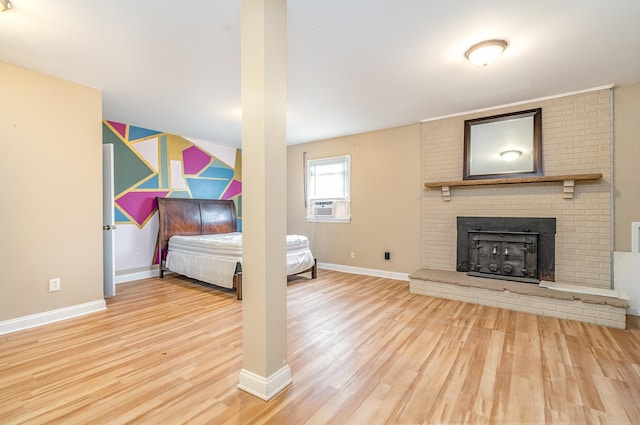 unfurnished bedroom featuring hardwood / wood-style floors, a fireplace, and cooling unit