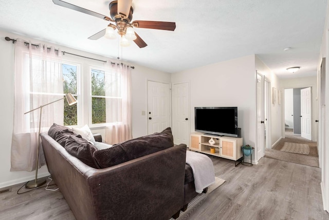 living room with light hardwood / wood-style floors and ceiling fan