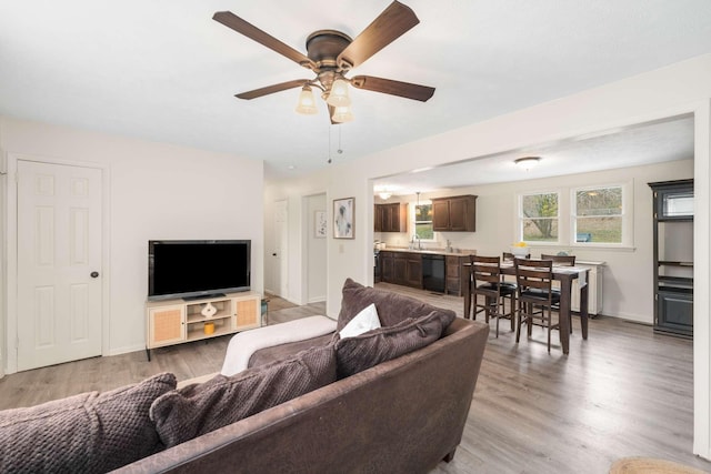 living room with ceiling fan, sink, and hardwood / wood-style floors