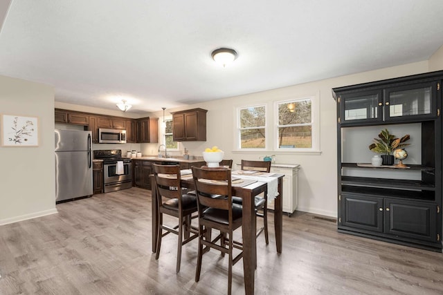 dining space with sink and light hardwood / wood-style flooring