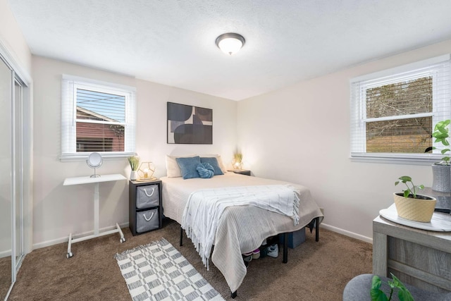 bedroom featuring a closet, dark carpet, and a textured ceiling