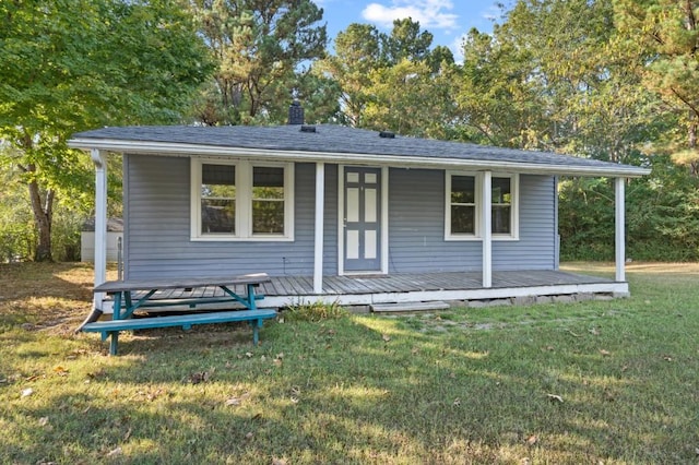 back of house with an outdoor structure and a lawn