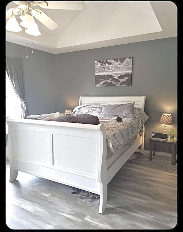 bedroom with wood-type flooring, vaulted ceiling, and ceiling fan