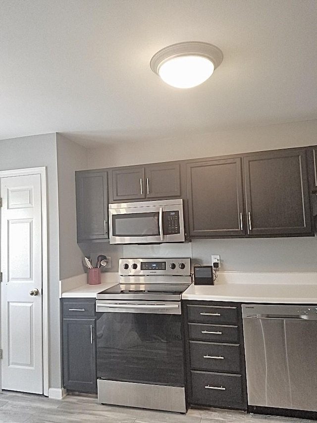 kitchen with light hardwood / wood-style floors and appliances with stainless steel finishes