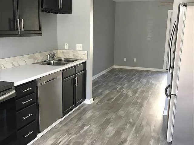 kitchen featuring appliances with stainless steel finishes, sink, and dark hardwood / wood-style flooring