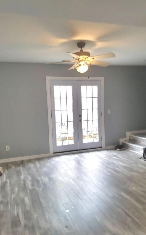 empty room with wood-type flooring, french doors, and ceiling fan