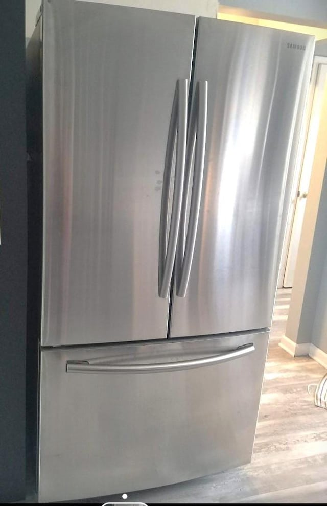 room details featuring stainless steel refrigerator and light hardwood / wood-style flooring