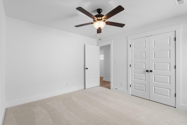 unfurnished bedroom with light carpet, a closet, and ceiling fan