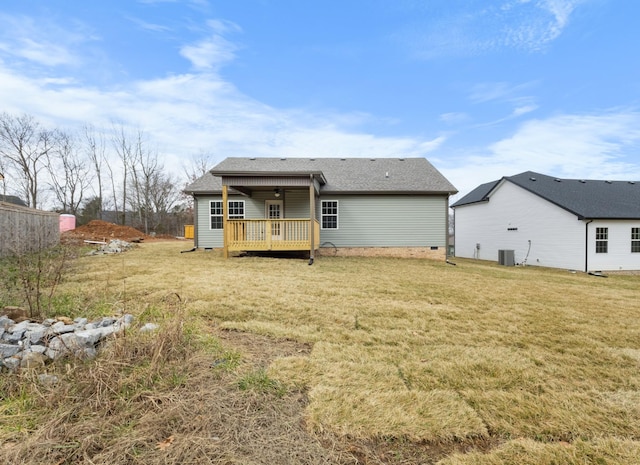 rear view of house featuring a wooden deck, a lawn, and central air condition unit