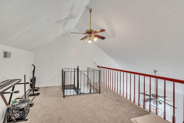 interior space featuring vaulted ceiling, carpet, and a textured ceiling