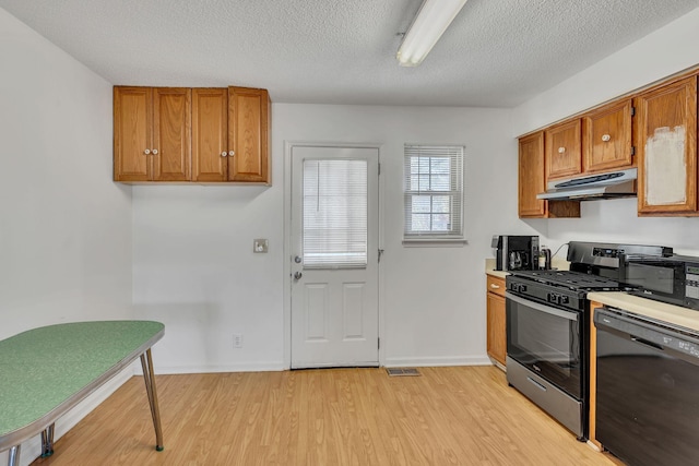 kitchen featuring a textured ceiling, light wood-type flooring, and black appliances